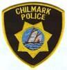 police badge with words Chilmark Police with gold seal and catboat in center of seal with black background 